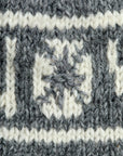 Close-up of a knitted fabric with a pattern and text.